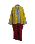 Yellow coat with black and white striped trim and red patterned skirt on a white background